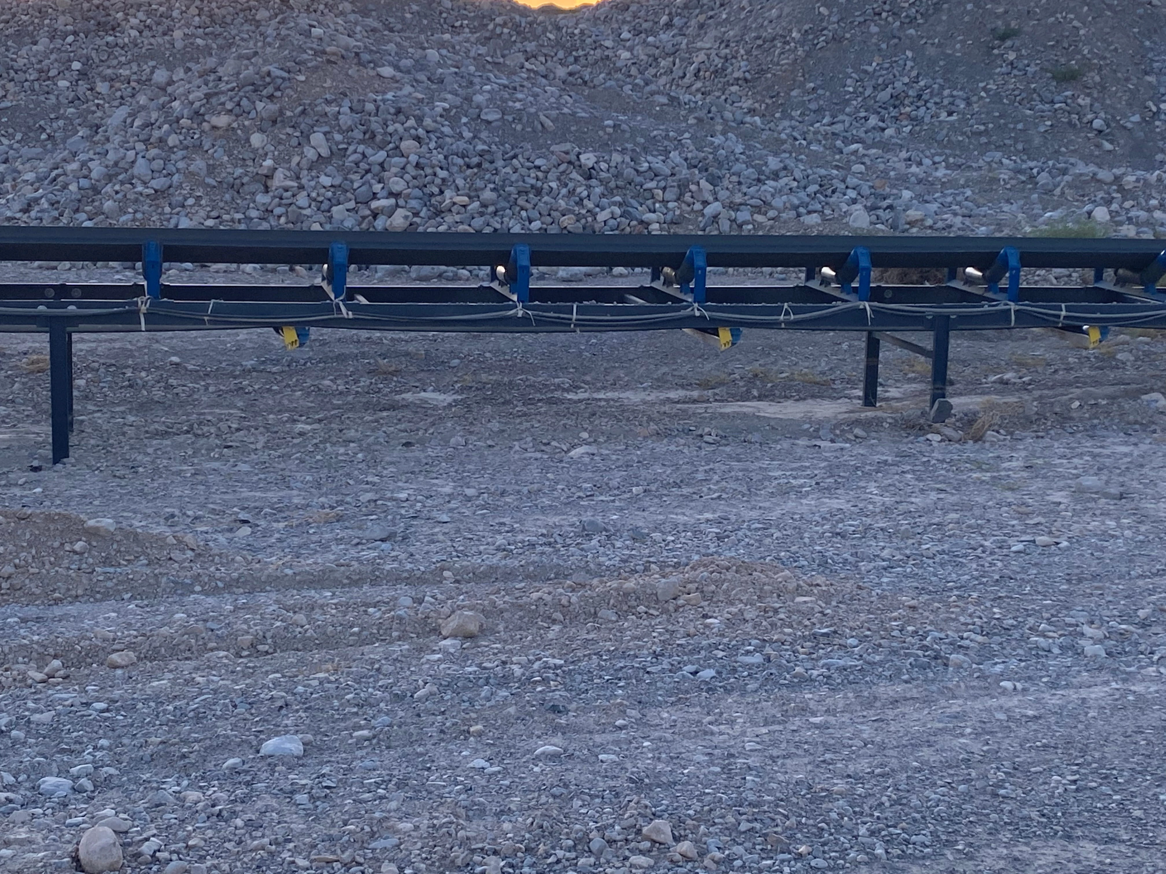 Close-up of Apache conveyor troughing idler rollers on a support frame